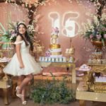 A beautiful quinceañera party setup with an elegant cake, floral decor, and a young woman in a white dress.